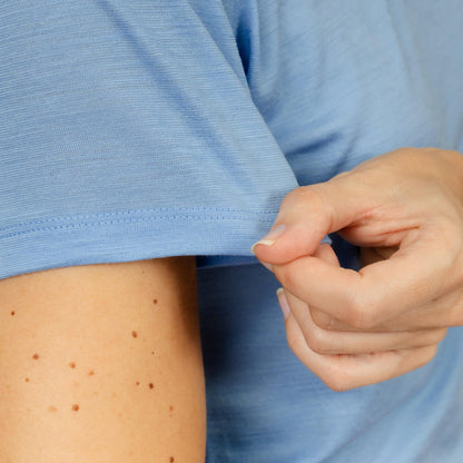 Model mit Merino Damen Shirt mit V-Ausschnitt von TOM FYFE Nahaufnahme Ärmel in Steelblue 