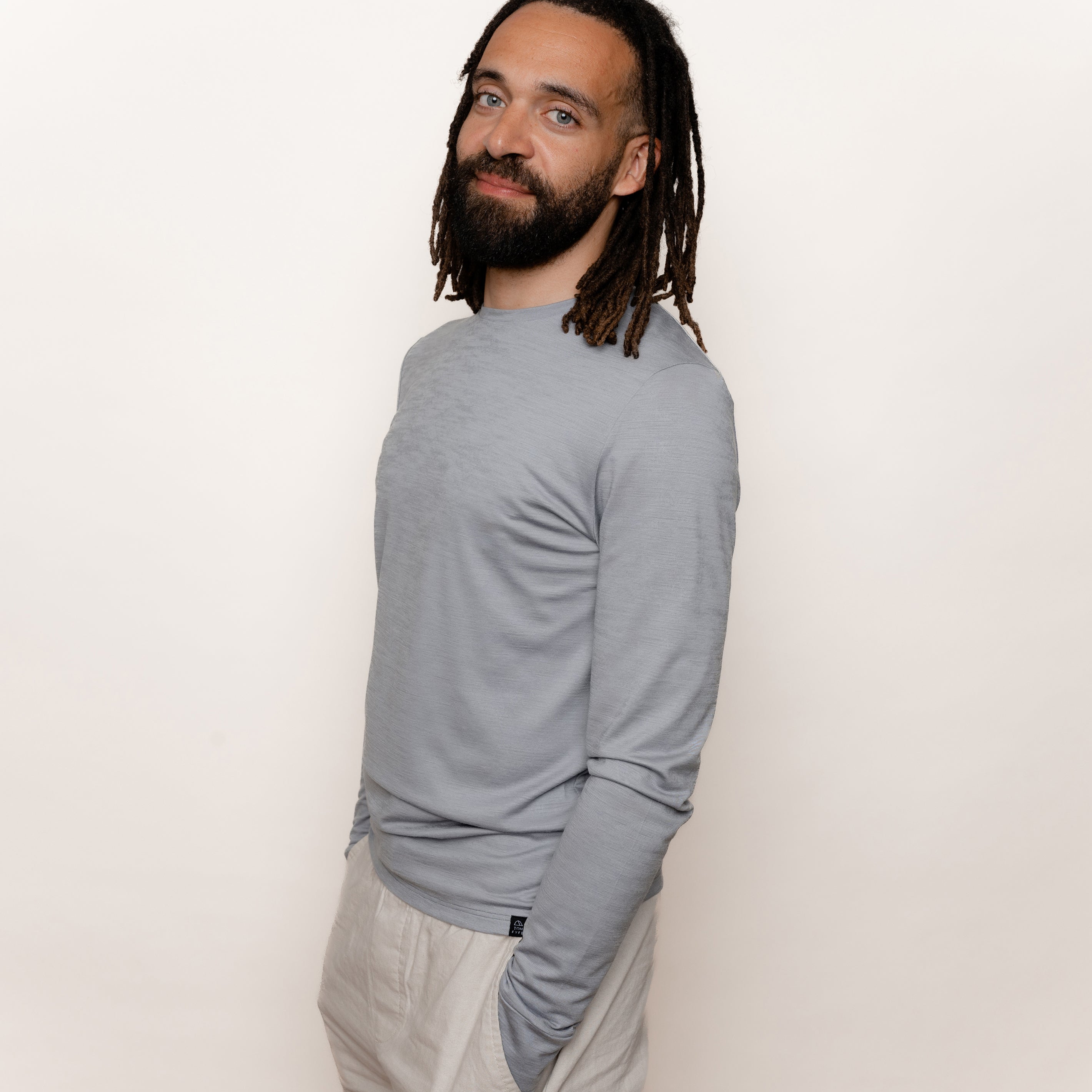 Model mit Merino Herren Langarmshirt Seitenansicht von Tom Fyfe in Hellgrau 