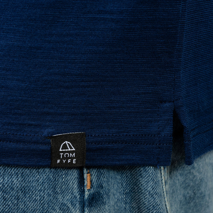 Model mit Merino Herren Poloshirt Label von Tom Fyfe in Marine #farbe_marine