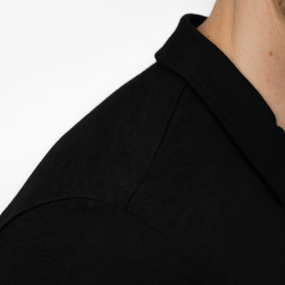 Model mit Merino Herren Poloshirt Nahaufnahme von Tom Fyfe in Schwarz 