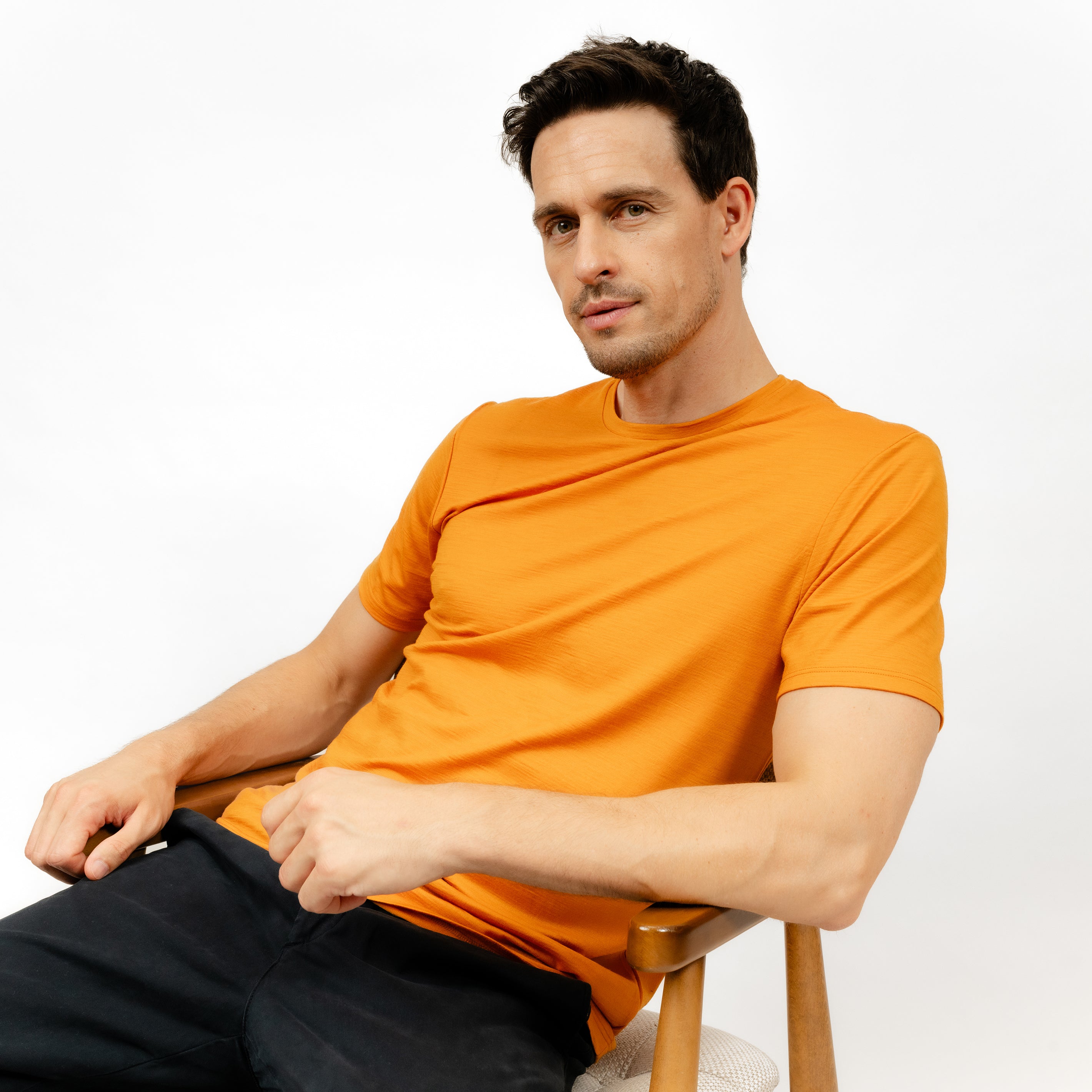 Männliches Model mit Merino T-Shirt Regular Fit Unisex Seitenansicht von TOM FYFE in Kurkuma 