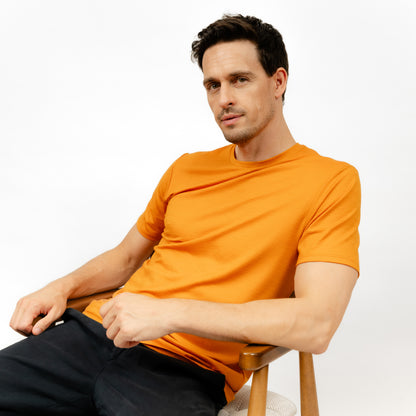 Männliches Model mit Merino T-Shirt Regular Fit Unisex Seitenansicht von TOM FYFE in Kurkuma 
