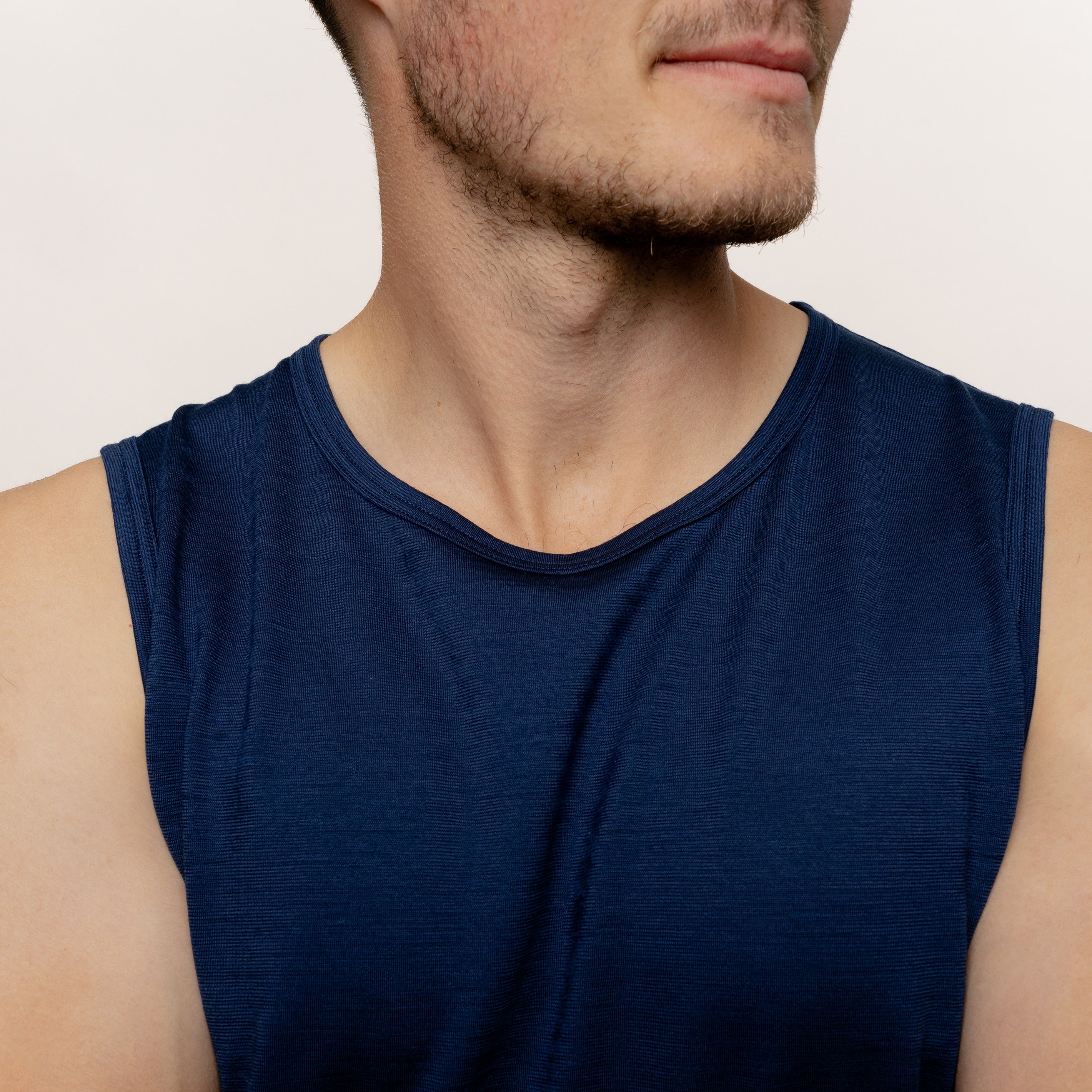 Model mit Merino Herren Tank-Top von Tom Fyfe in Marine Nahaufnahme Arm Brust Bereich 