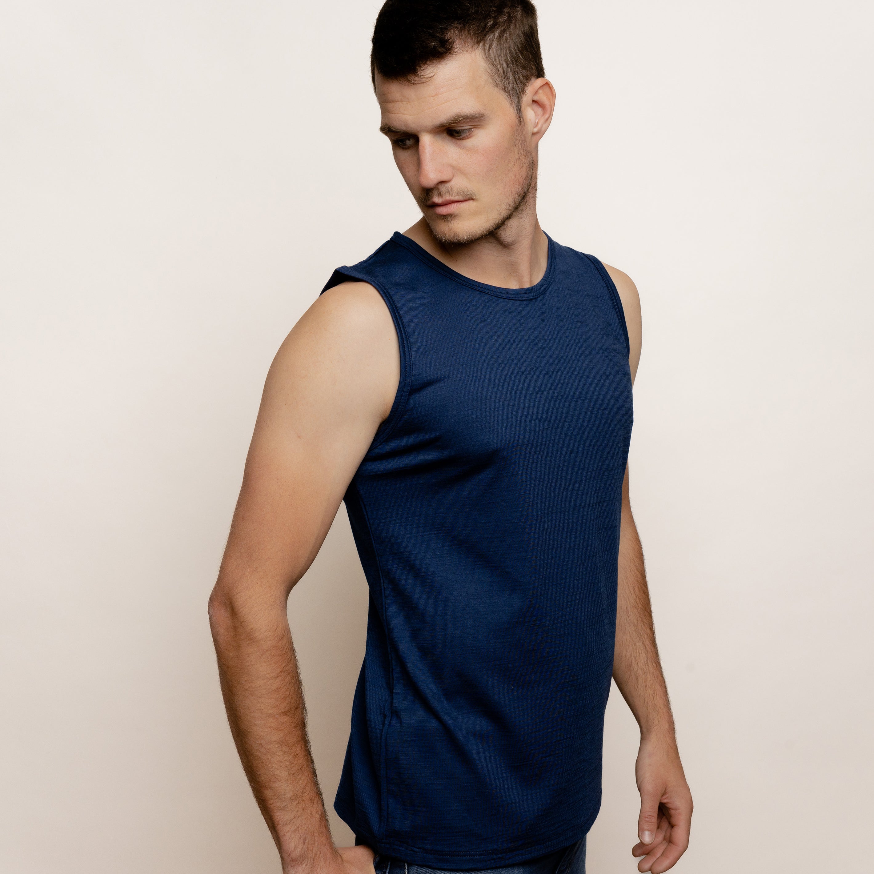 Model mit Merino Herren Tank-Top von Tom Fyfe in Marine Seitenansicht #farbe_marine