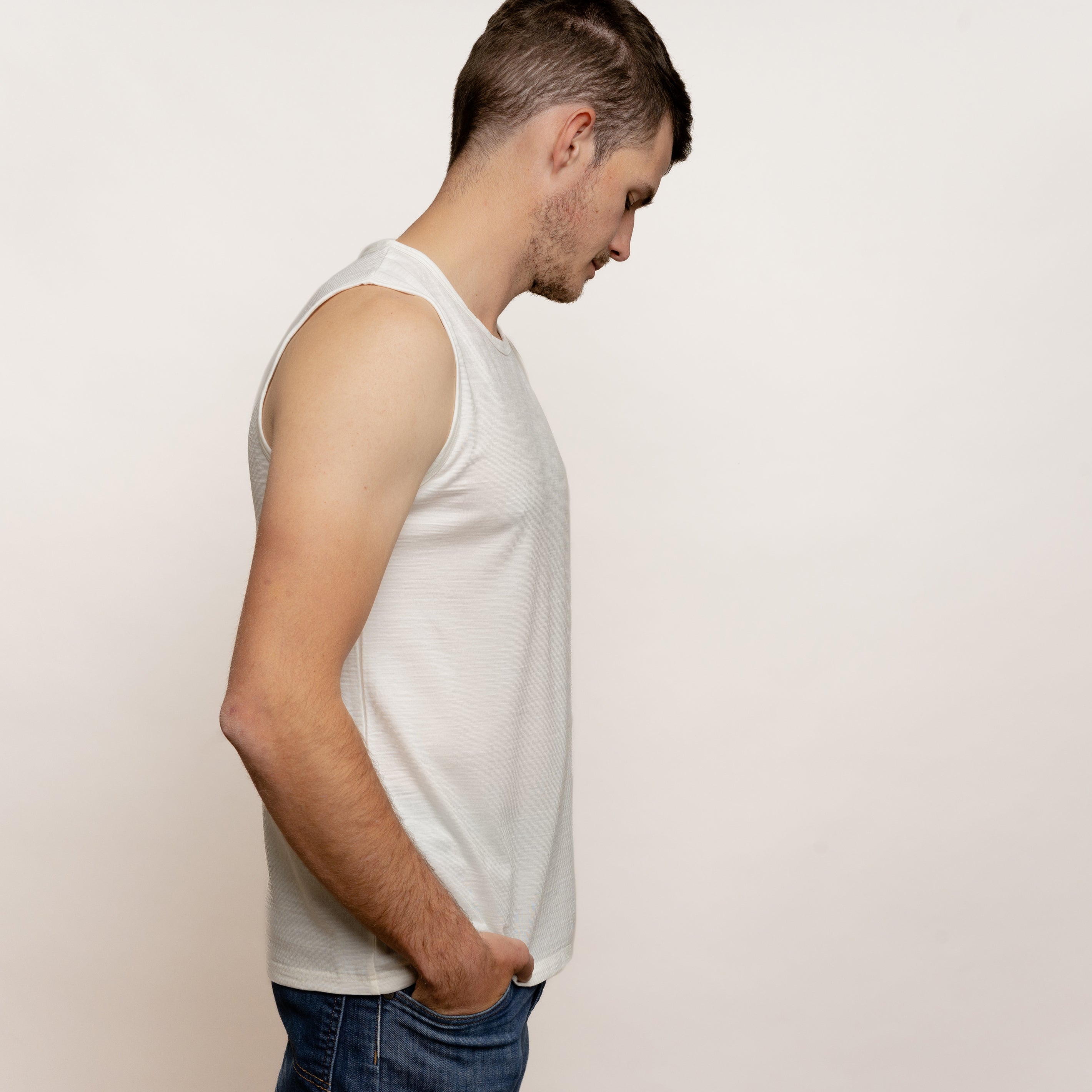 Model mit Merino Herren Tank-Top von Tom Fyfe in Wollweiß Seitenansicht in Bewegung 