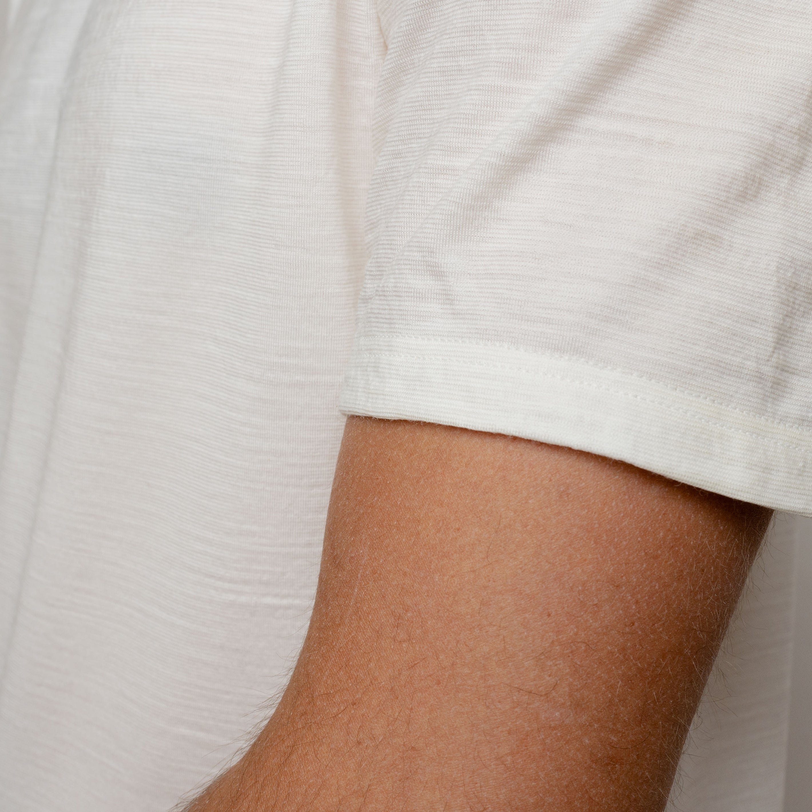 Merino Herren Shirt mit V-Ausschnitt von Tom Fyfe in Wollweiss Detailaufnahme des Ärmels