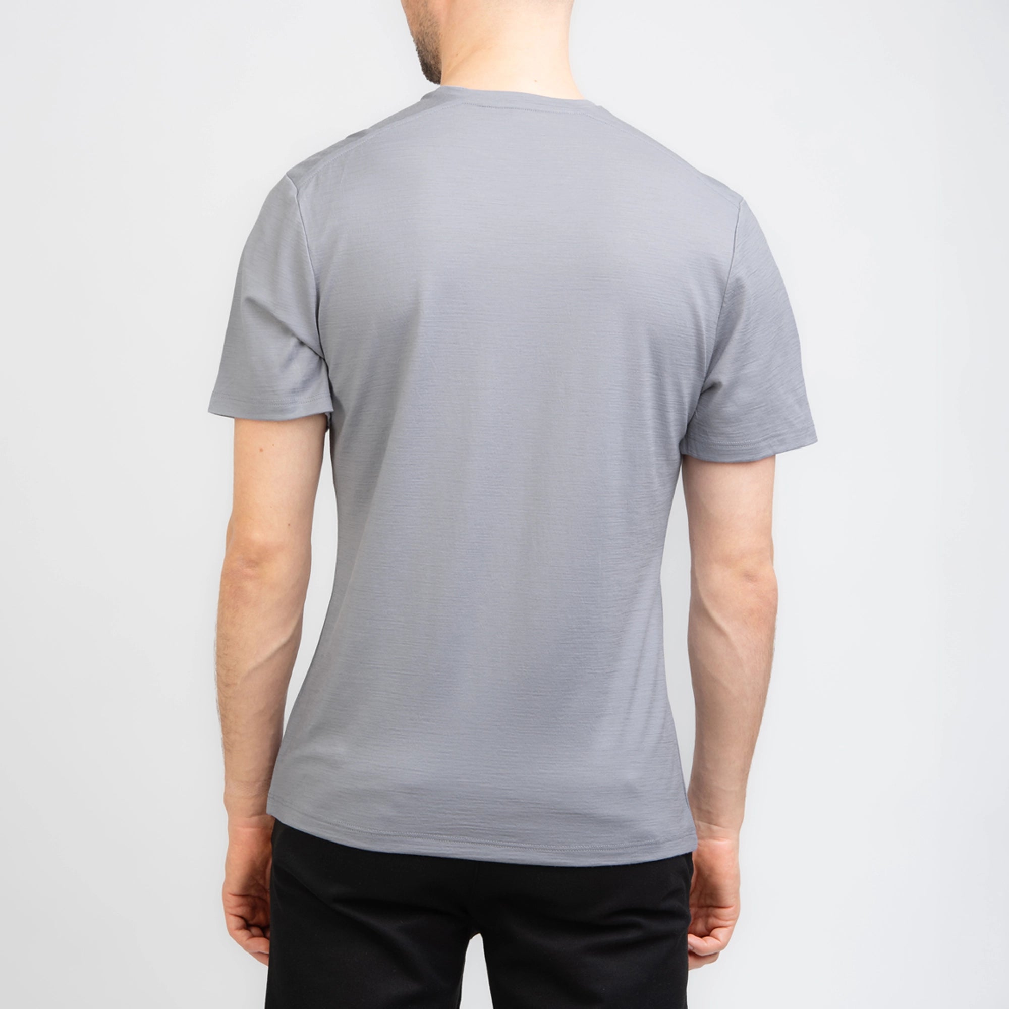 Model mit Merino Herren Shirt von TOM FYFE in Hellgrau Rueckenansicht  