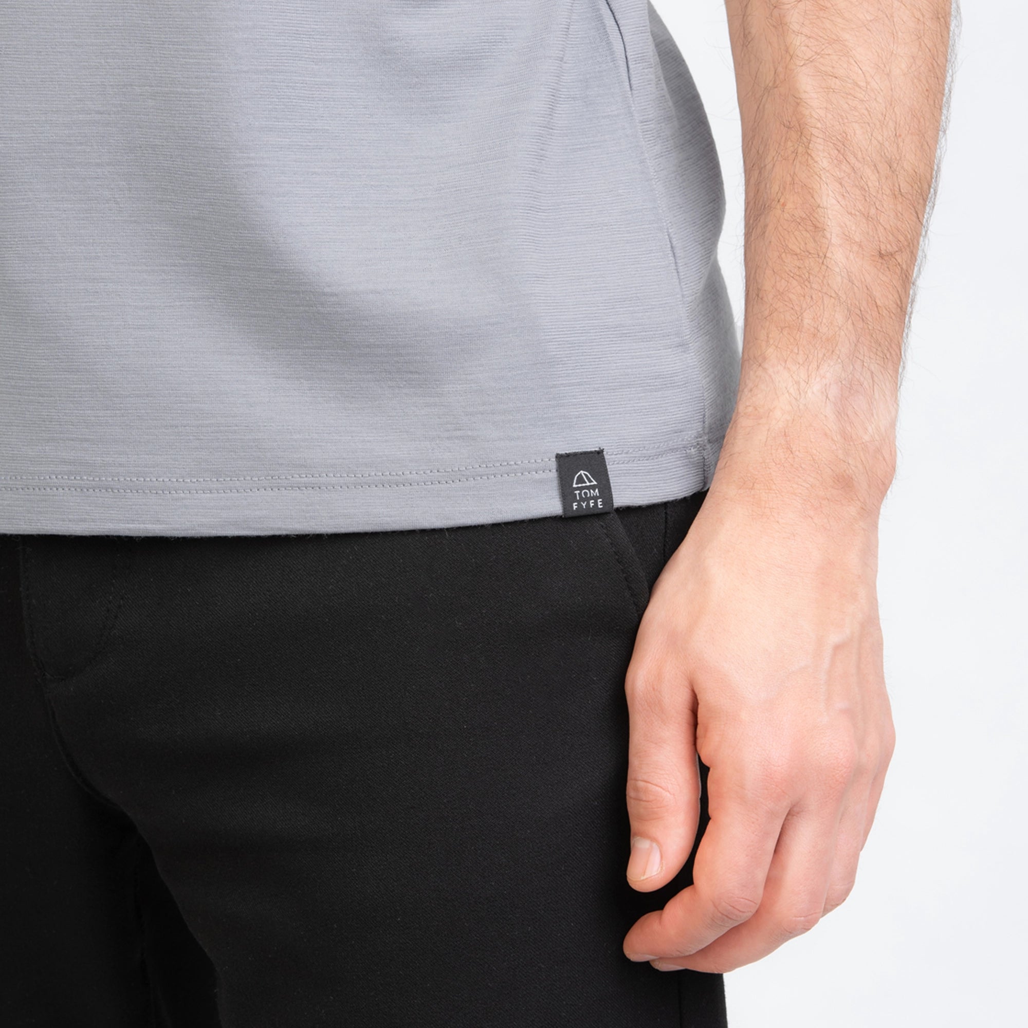 Model mit Merino Herren Shirt mit angenaehtem Stofflabel mit Logo von TOM FYFE in Hellgrau 