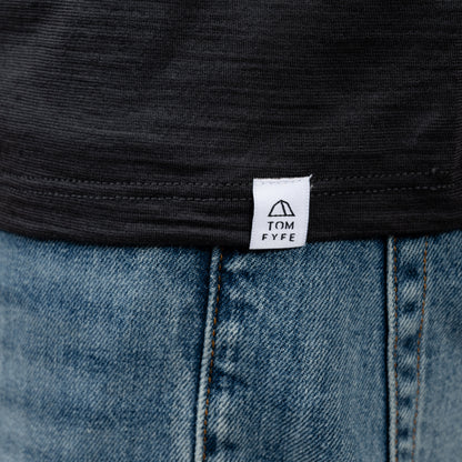 Model mit Merino T-Shirt Regular Fit Unisex mit angenaehtem Stofflabel mit Logo von Tom Fyfe in Anthrazit 