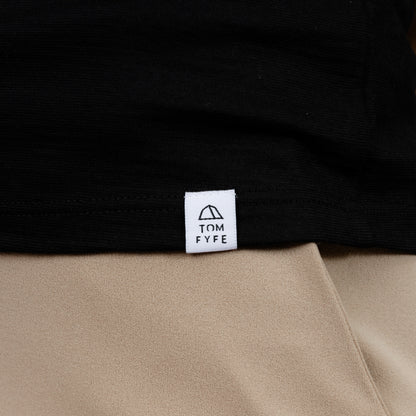 Model mit Merino T-Shirt Regular Fit Unisex mit angenaehtem Stofflabel mit Logo von Tom Fyfe in Schwarz 