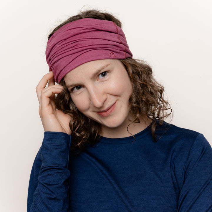 Weibliches Model mit Merino Schlauchschal Multifunktionstuch von Tom Fyfe in Brombeere als Kopfbedeckung #farbe_brombeere
