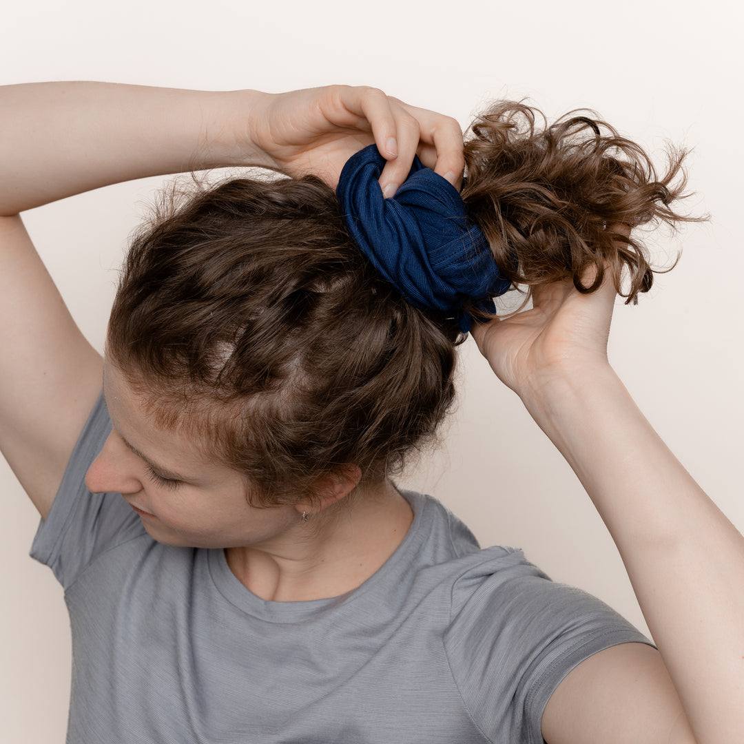 Weibliches Model mit Merino Schlauchschal Multifunktionstuch von Tom Fyfe in Marine als Haarband #farbe_marine
