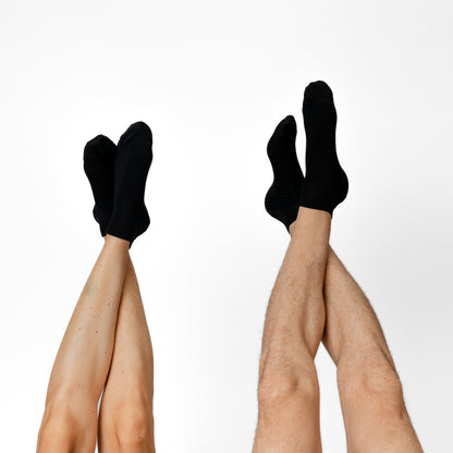 Merino Sneakersocken mit ausgestreckten Füßen von Tom Fyfe in Schwarz 