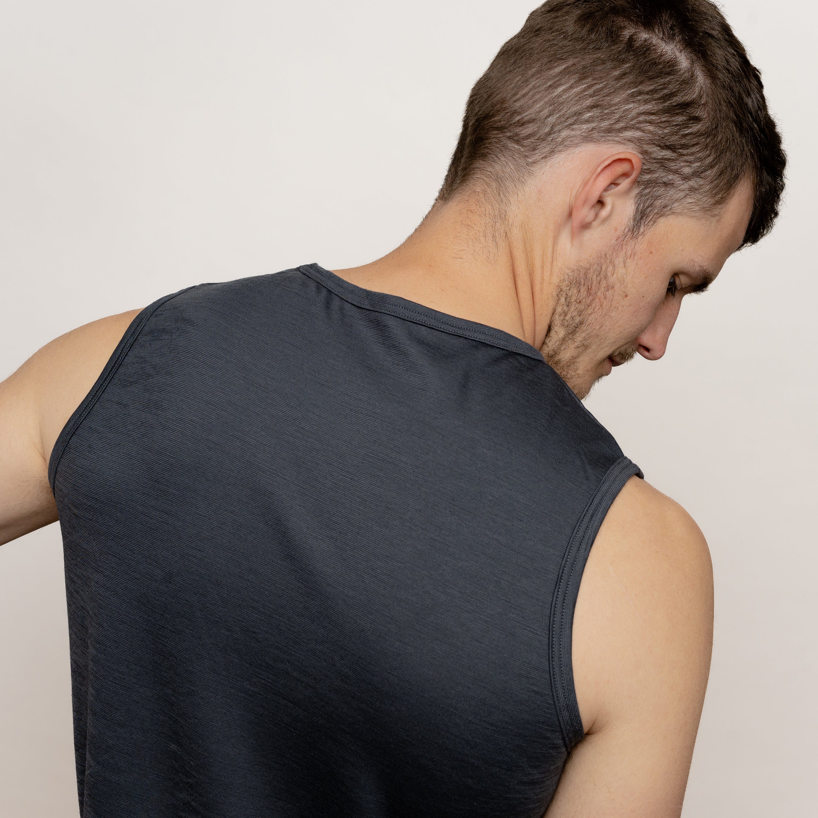 Model mit Merino Herren Tank-Top von Tom Fyfe in Anthrazit Nahaufnahme Rücken Nacken Bereich 