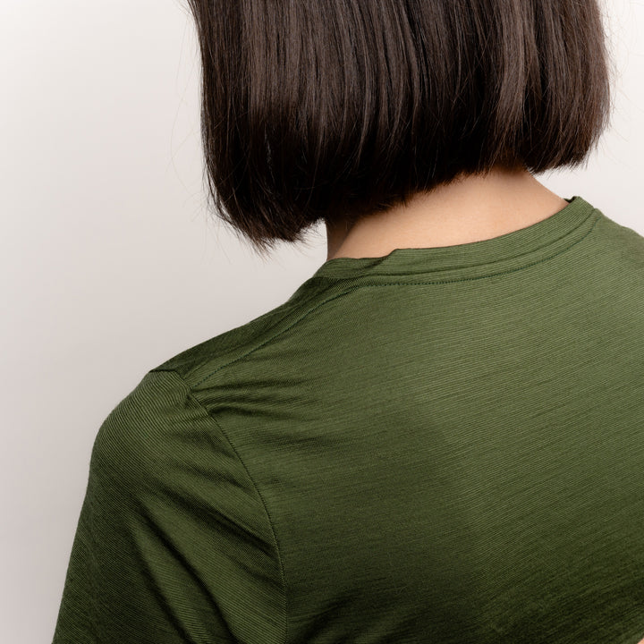 Model im Merino Damen Shirt mit Ausschnitt von Tom Fyfe in Wadgrün Detailaufnahme Schulter #farbe_waldgruen