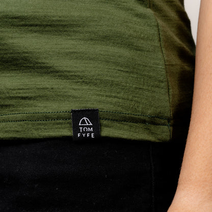 Model im Merino Damen Shirt mit Ausschnitt von Tom Fyfe in Wadgrün Saum mit angenähtem Logo 
