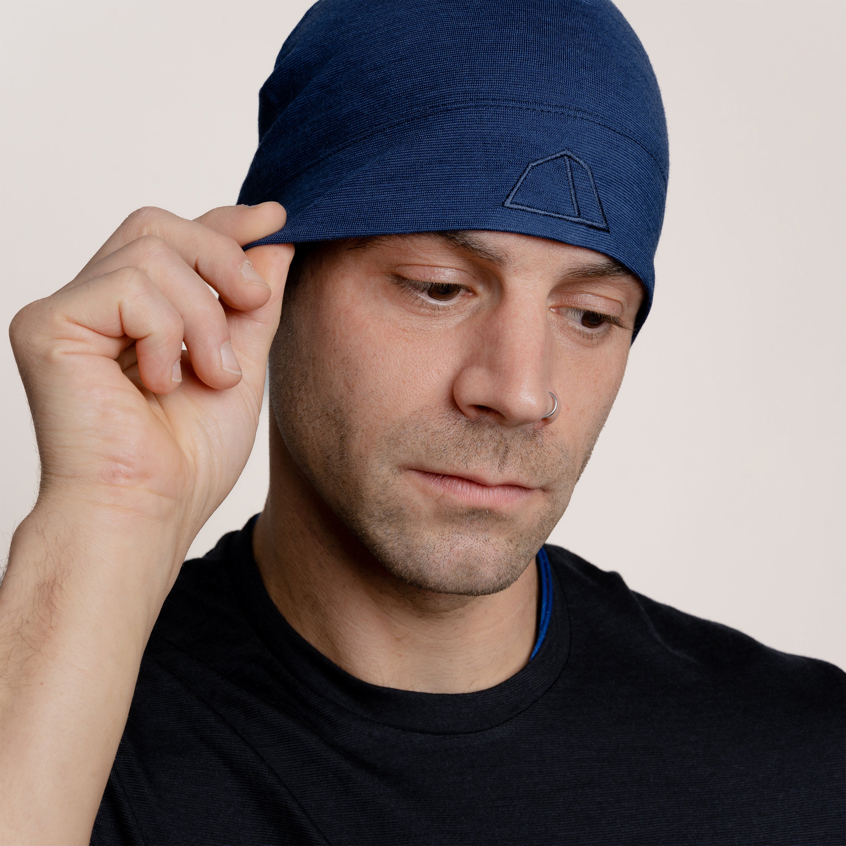 Männliches Model mit Merino Beanie Muetze dehnbar von Tom Fyfe in Marineblau #farbe_marine
