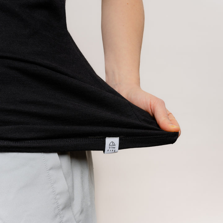 Model mit Merino Damen Shirt mit V-Ausschnitt mit angenaehtem Stofflabel von Tom Fyfe in Schwarz #farbe_schwarz