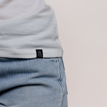 Model mit Merino Damen Shirt mit angenaehtem Stofflabel mit Logo von Tom Fyfe in Weiss 