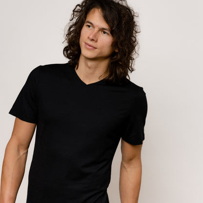 Model mit Merino Herren Shirt mit V-Ausschnitt Frontansicht von Tom Fyfe in Schwarz 