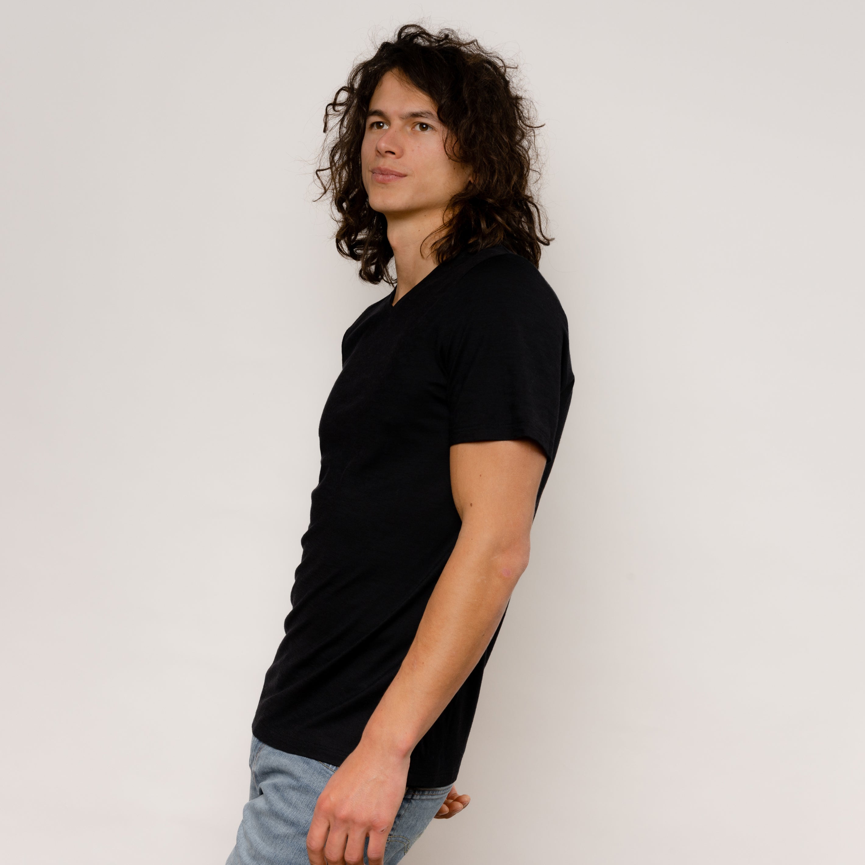 Model mit Merino Herren Shirt mit V-Ausschnitt Seitenansicht von Tom Fyfe in Schwarz 